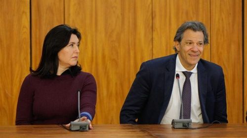 Simone Tebet e Fernando Haddad sentados lado a lado.
